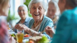 Elderly residents sharing a meal with caregivers and family around a dining table decorated for a cultural holiday.