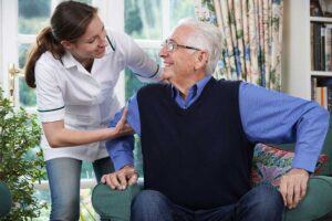 Resident and caregiver calmly discussing concerns at a table in a bright assisted living common room.