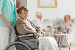 Older adults and children make crafts together around a bright assisted living activity table.